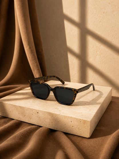Havana sunglasses displayed on a warm stone pedestal