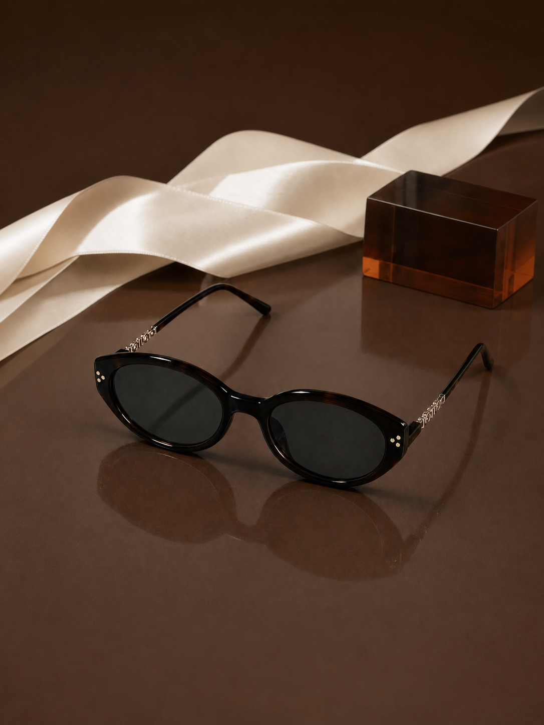 Sable sunglasses styled with ivory ribbon and amber block
