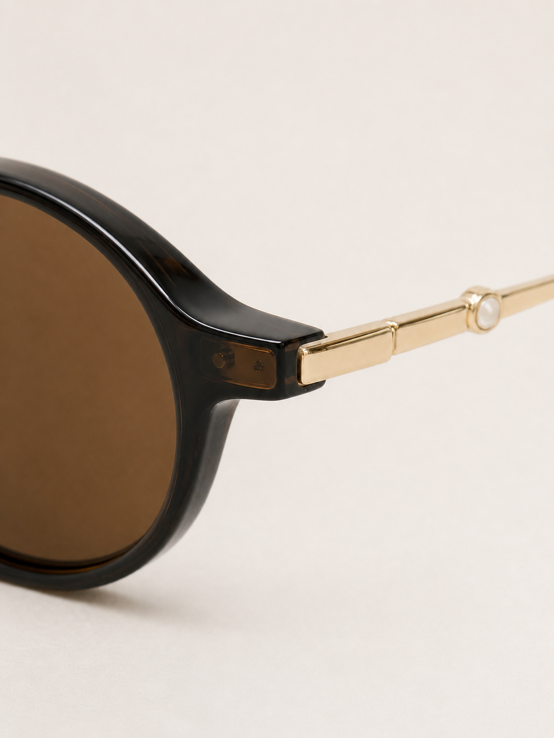 Close-up of the Sienna brown frame hinge and slim gold-tone temple