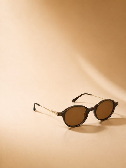 Sienna brown oval sunglasses in a warm editorial studio scene